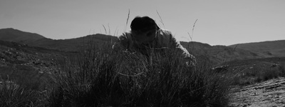 a person standing in a field with mountains in the background