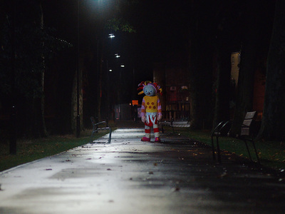 a person in a costume walking down a street at night