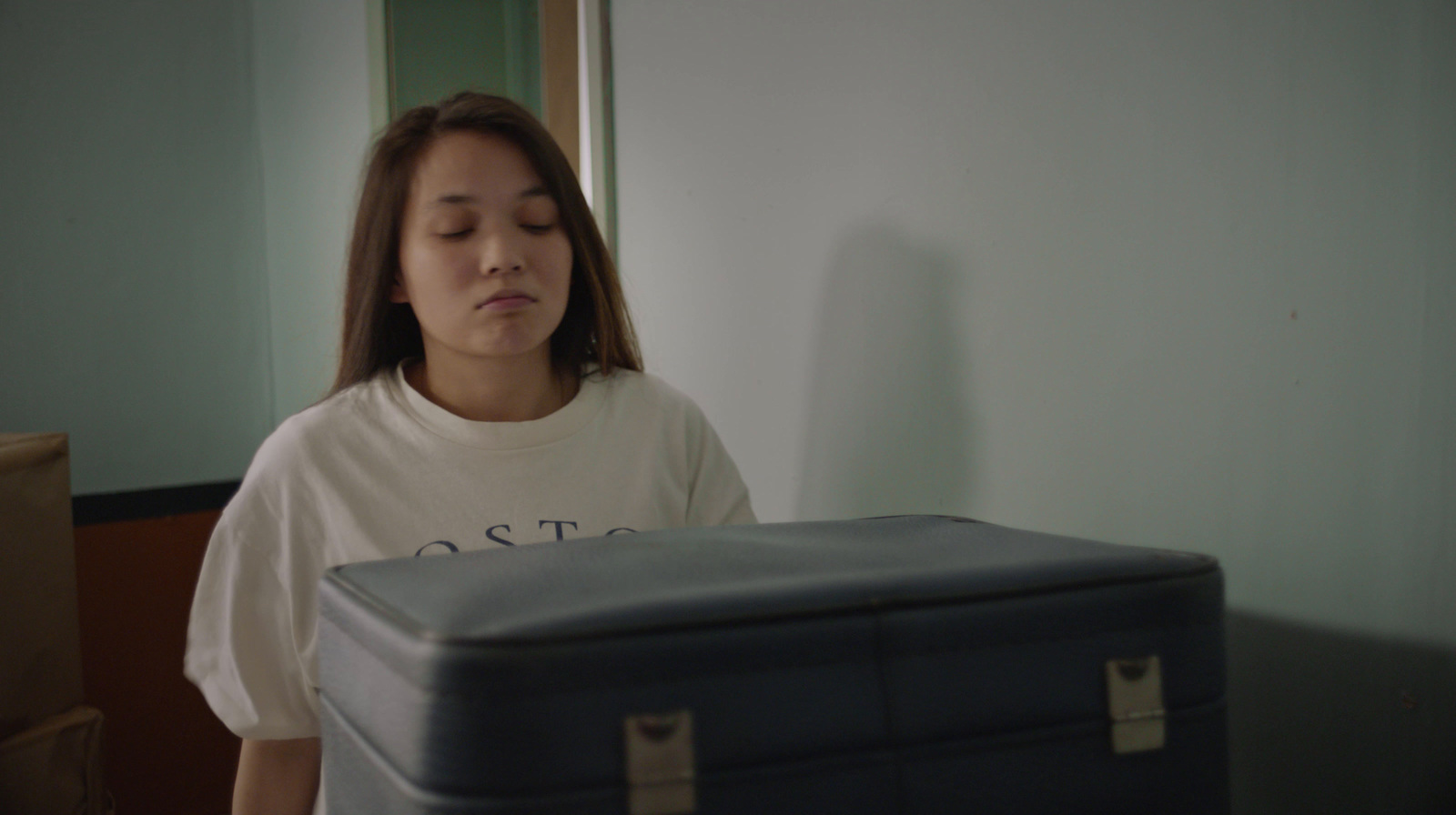 a woman standing next to a blue suitcase