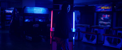 a person standing in a room with a neon light