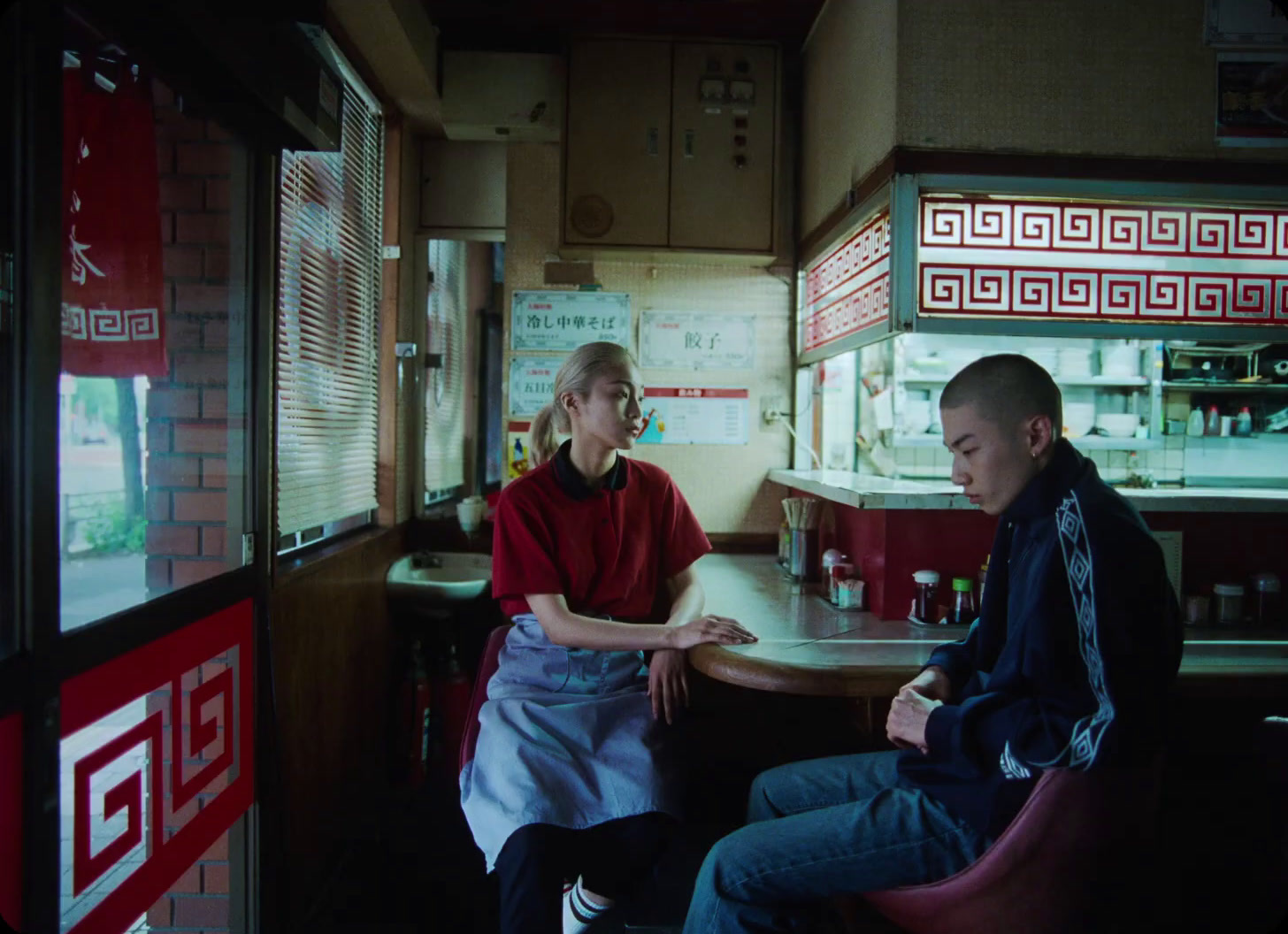 a man and a woman sitting at a table in a diner