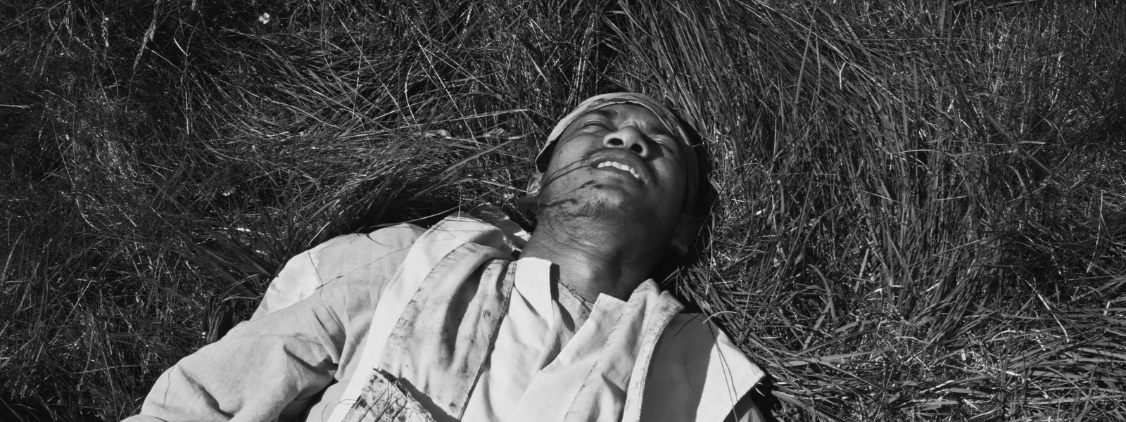 a black and white photo of a man laying on the ground