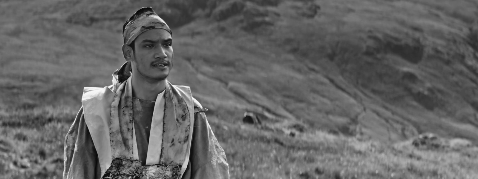 a man with a turban standing in a field