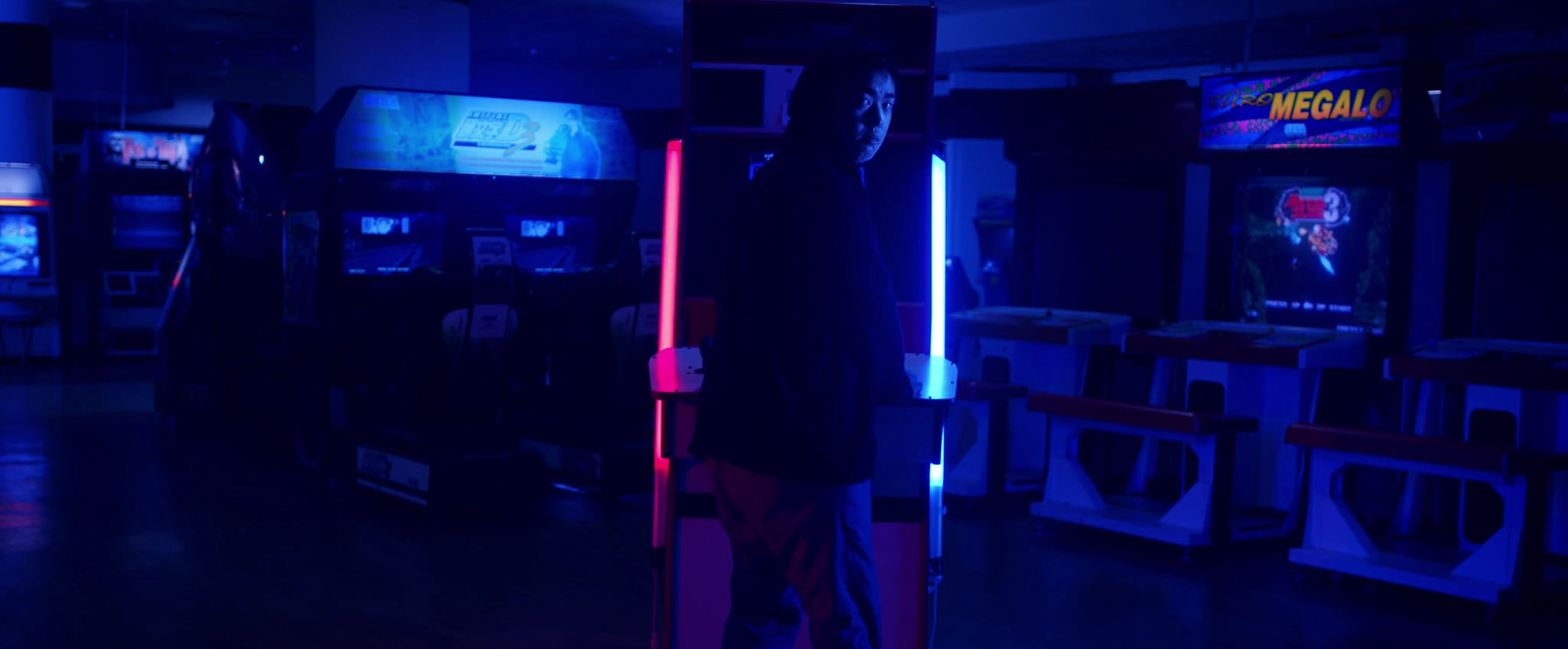 a man standing in front of a row of video game machines