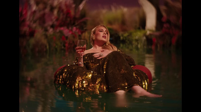 a woman sitting in the water with a glass of wine