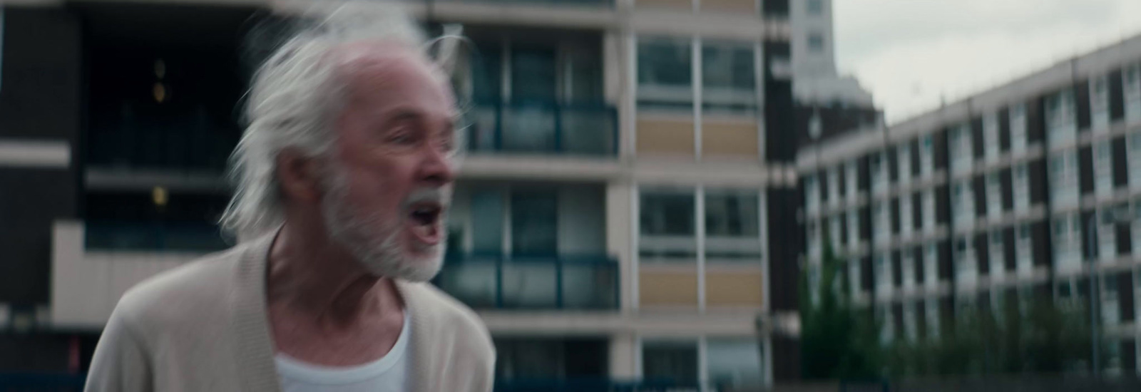 a man with white hair and a beard in a city