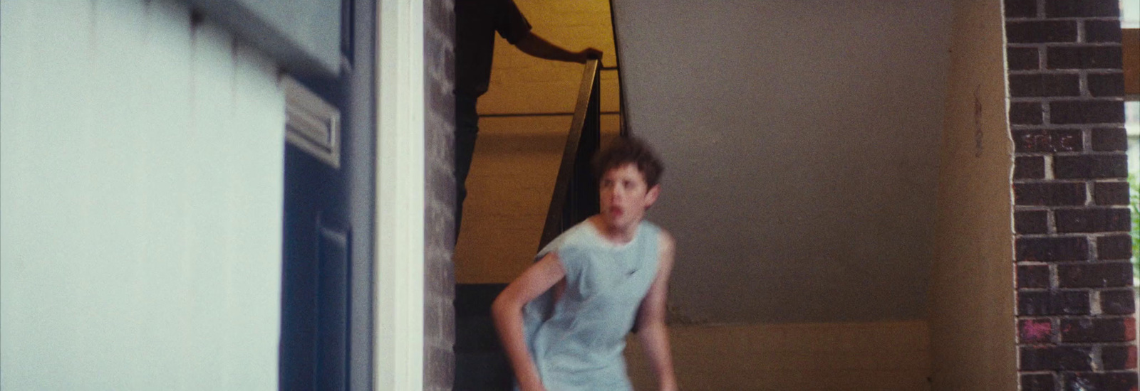 a young man standing in a doorway with a frisbee