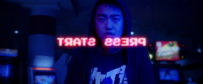 a man standing in front of a neon sign