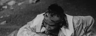 a black and white photo of a man holding a bird