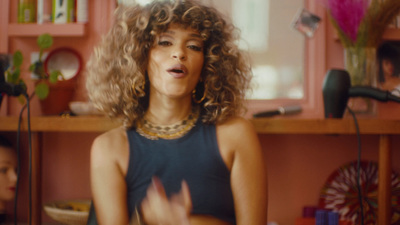 a woman with curly hair standing in a kitchen