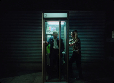 a man and a woman standing in a doorway at night