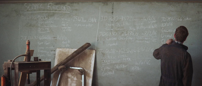 a man writing on a wall with chalk