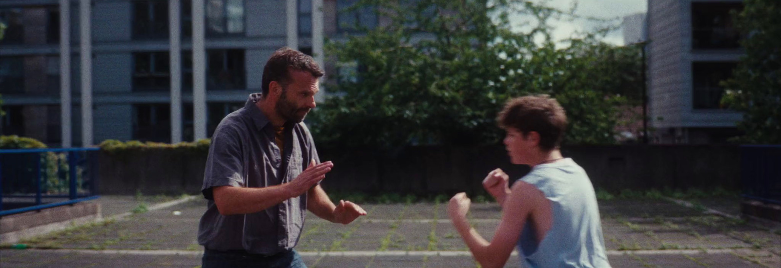 a man standing next to another man in a parking lot