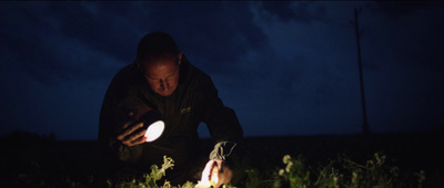 a man kneeling down in the grass holding a frisbee