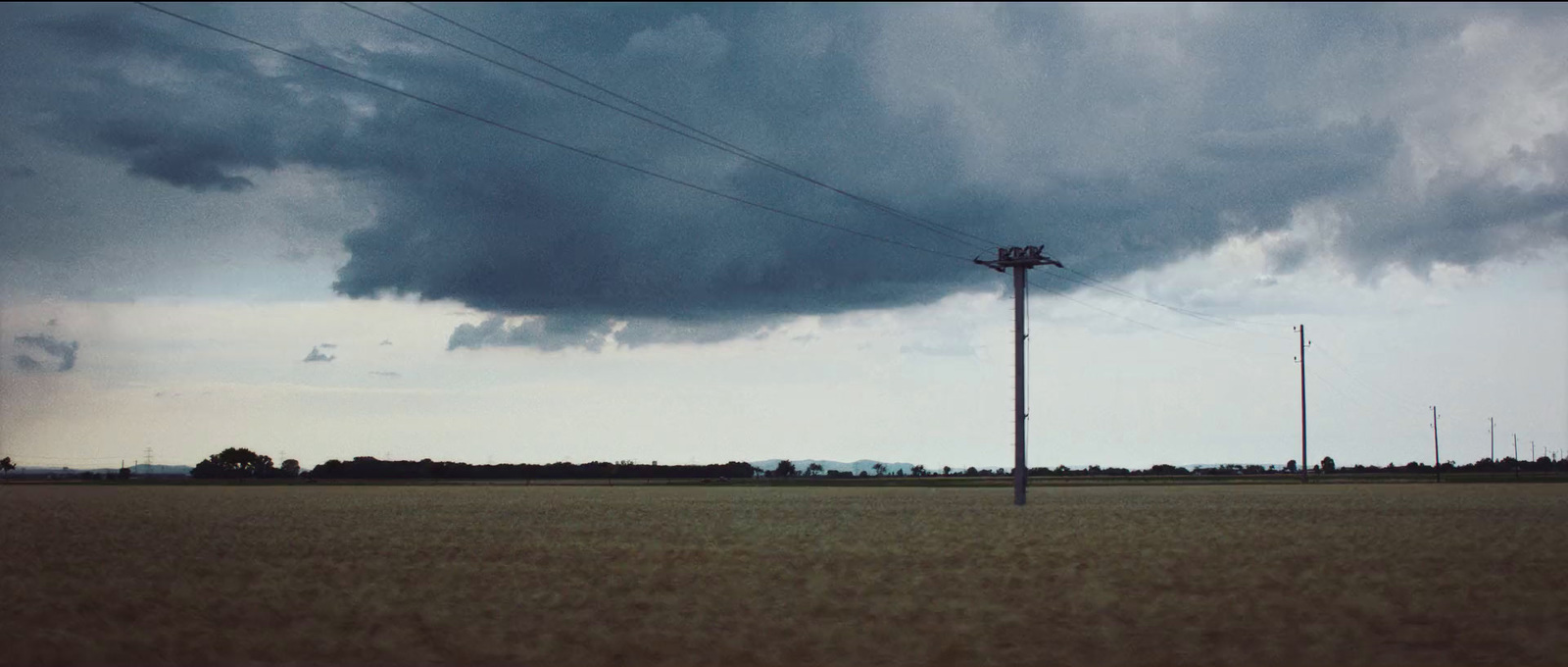 a field with a telephone pole in the middle of it