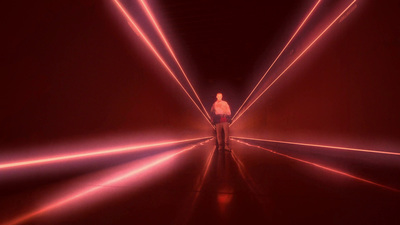 a man standing in a tunnel of red light