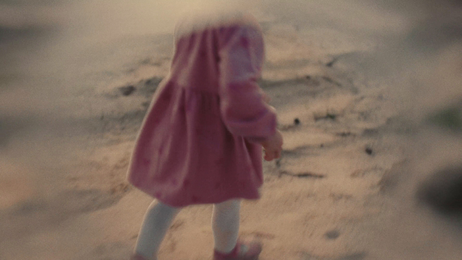 a blurry photo of a little girl in a pink coat