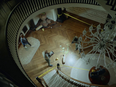 a man standing in a living room next to a chandelier