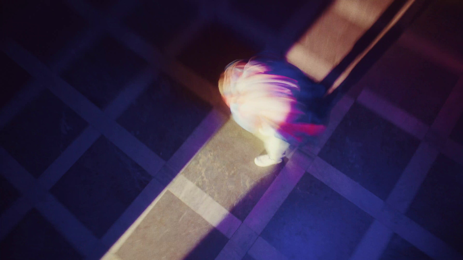 a blurry image of a cat on a tile floor