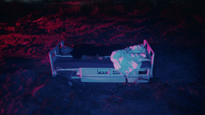 a person laying on a bed in the dark