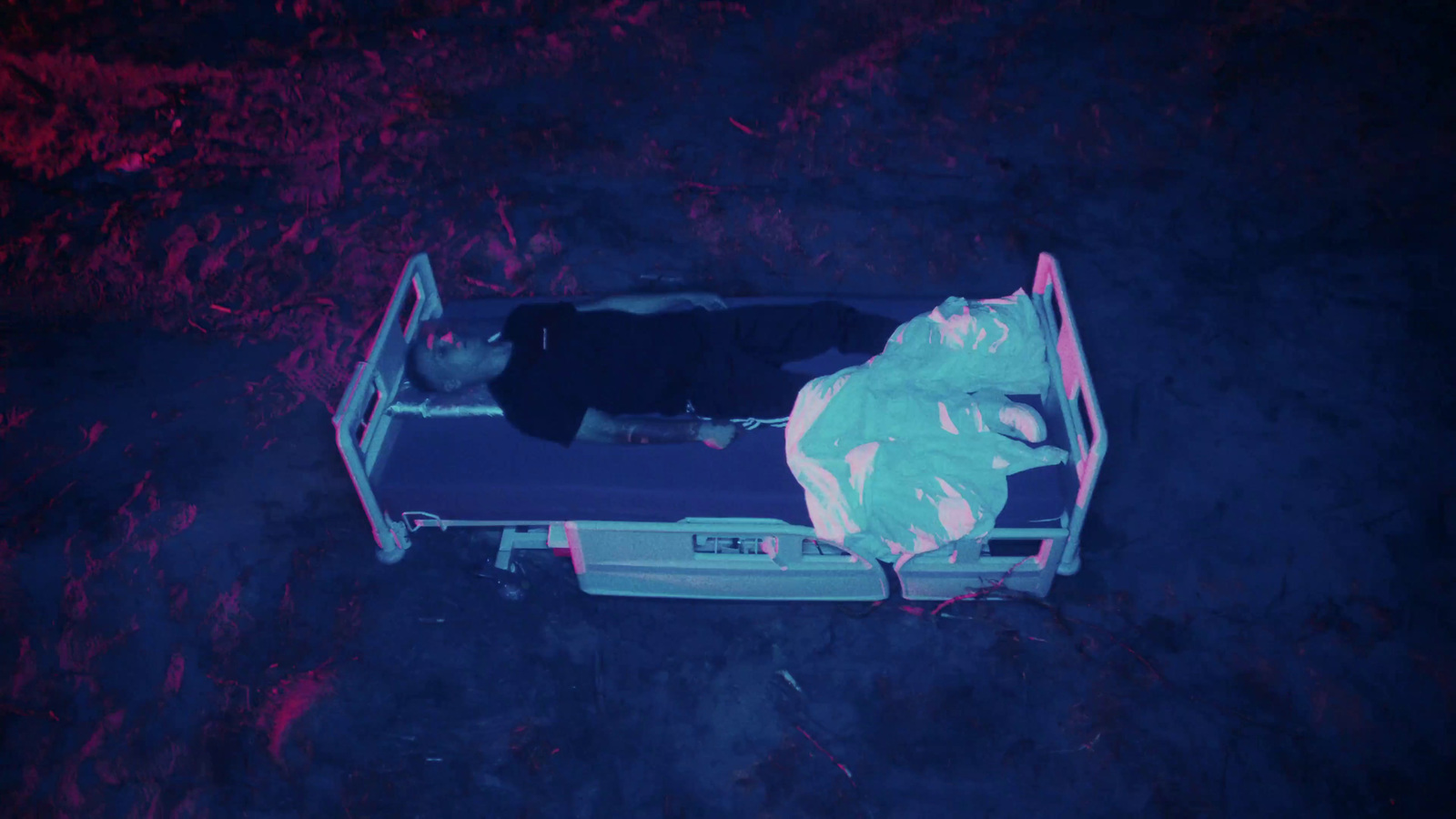 a person laying on a bed in the dark