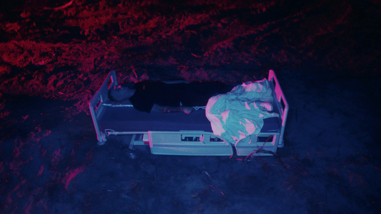 a person laying on a bed in the dark