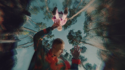 a man reaching up into the air to catch a frisbee