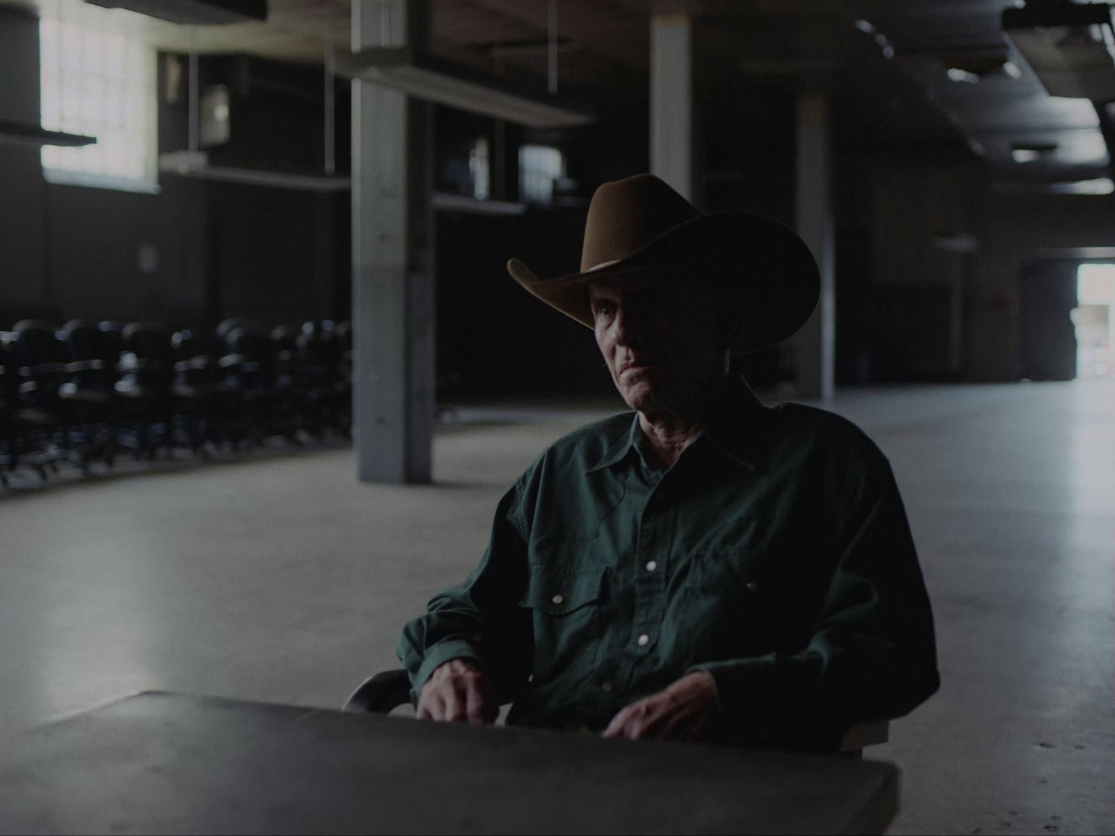 a man wearing a cowboy hat sitting at a table