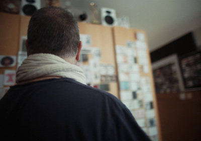 a man standing in front of a wall with pictures on it