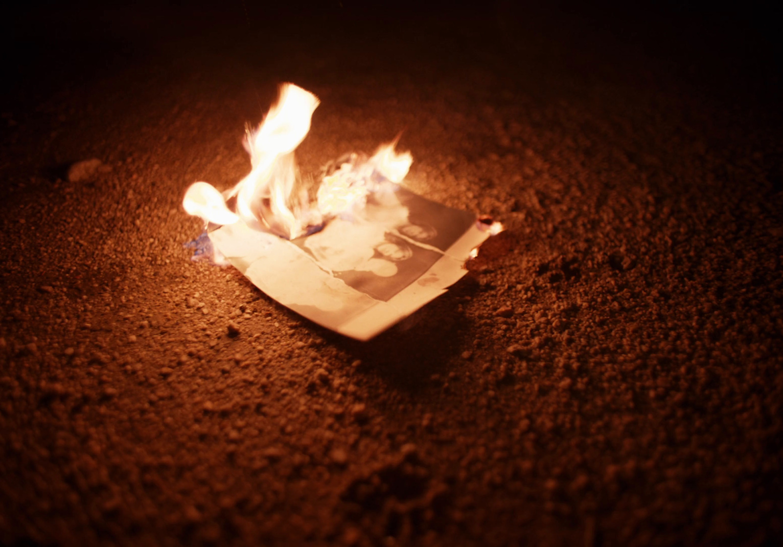 a piece of paper sitting on top of a sandy ground