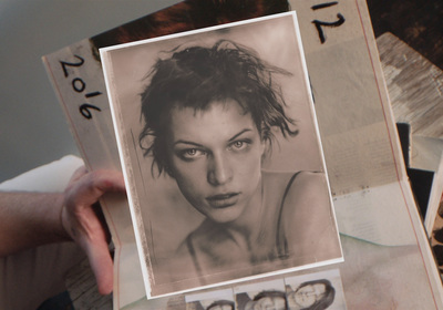 a person holding up a picture of a woman