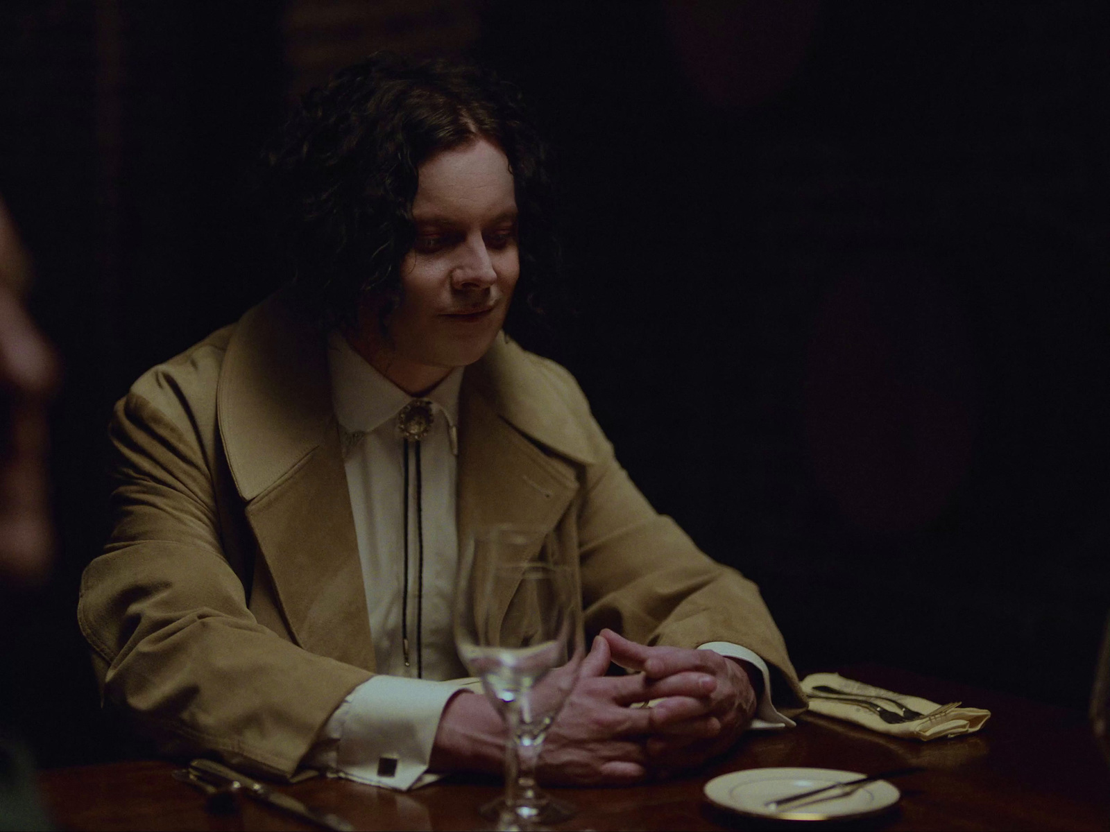 a man sitting at a table with a wine glass