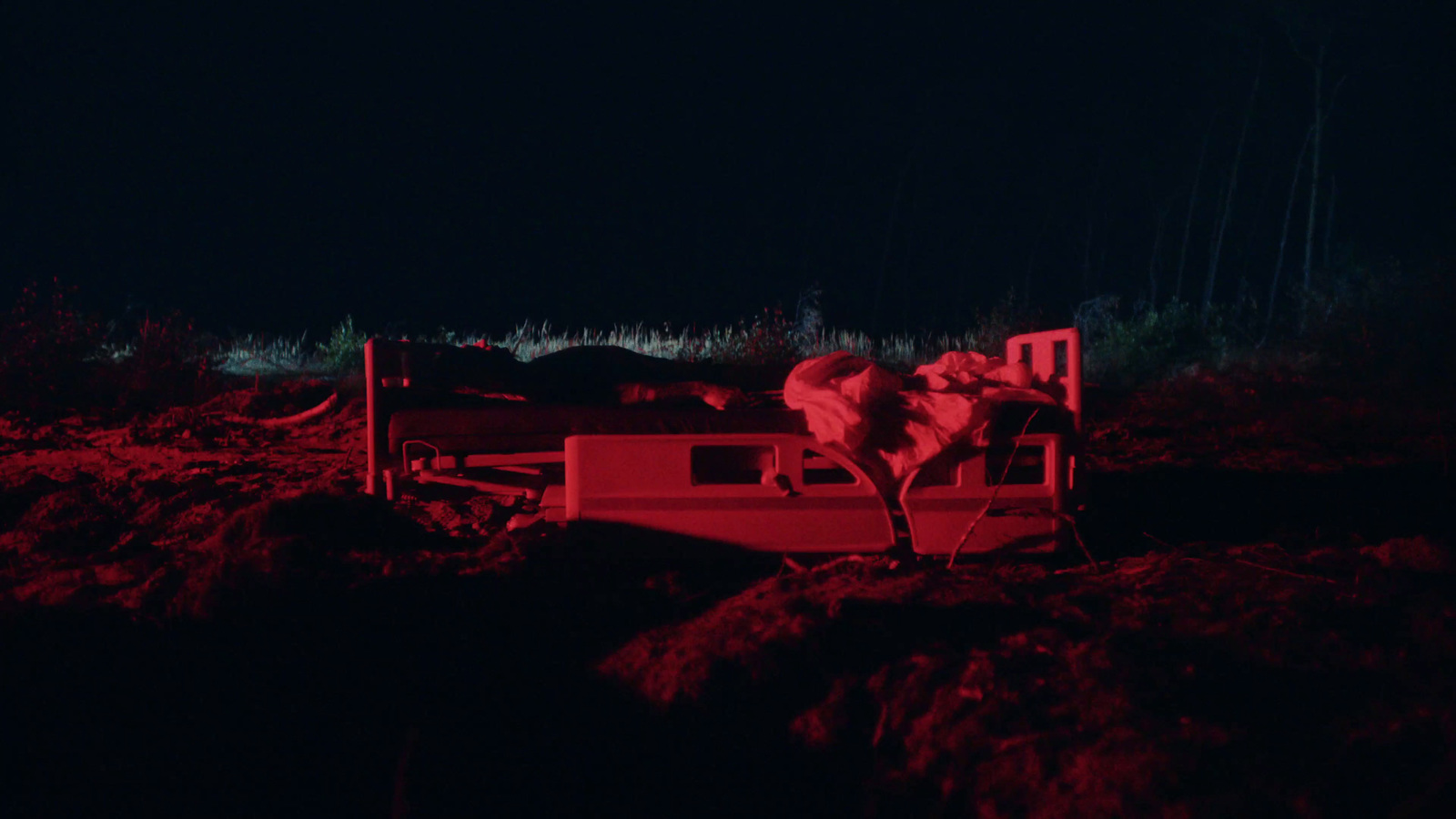 a person laying on a bench in the dark