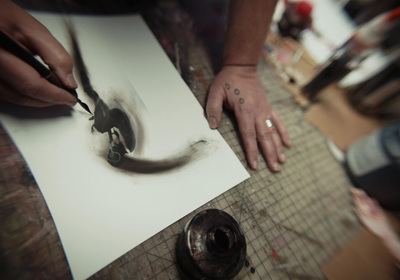 a person cutting a piece of paper with a knife