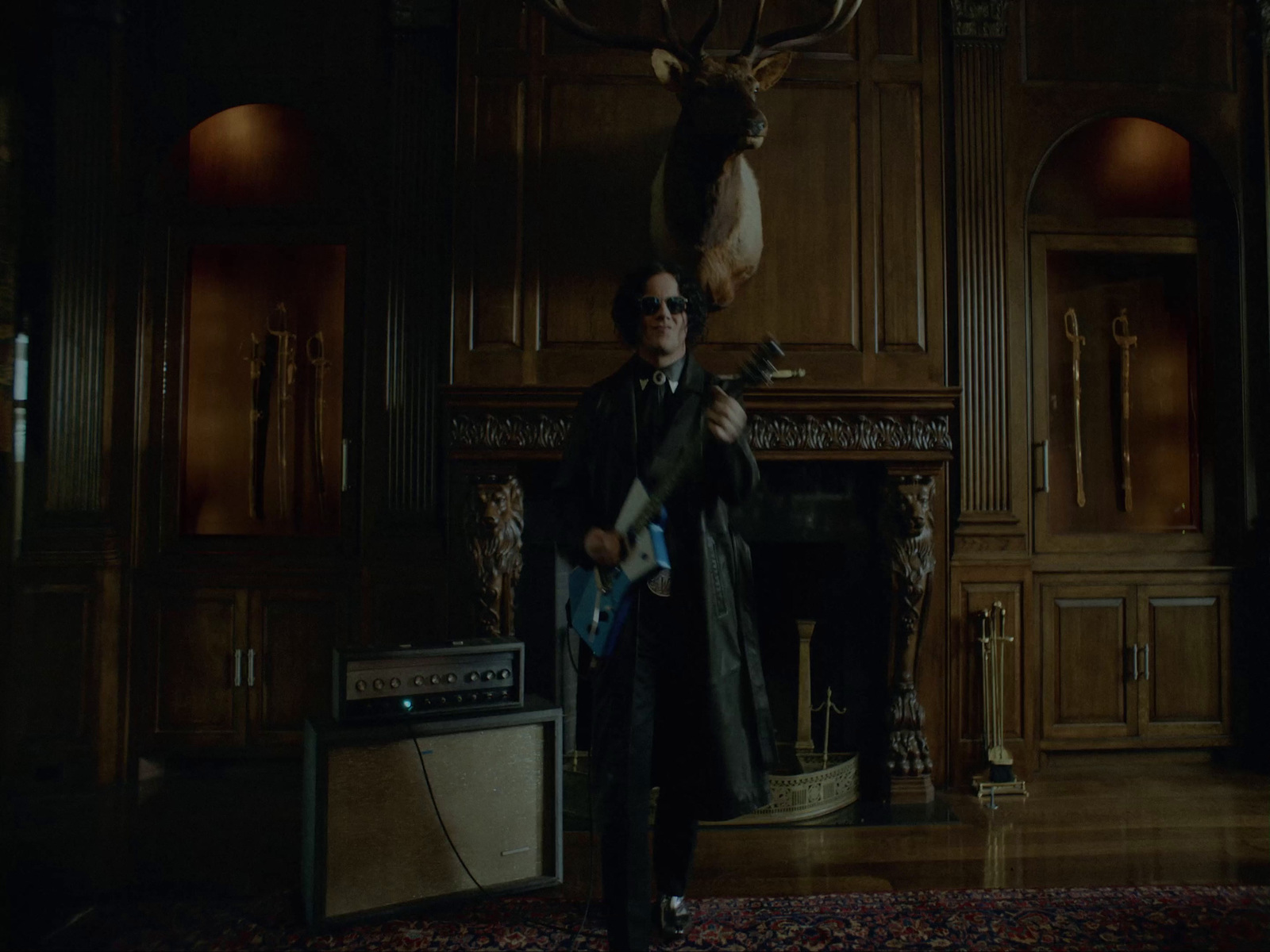 a man standing in a room with a deer head on the wall