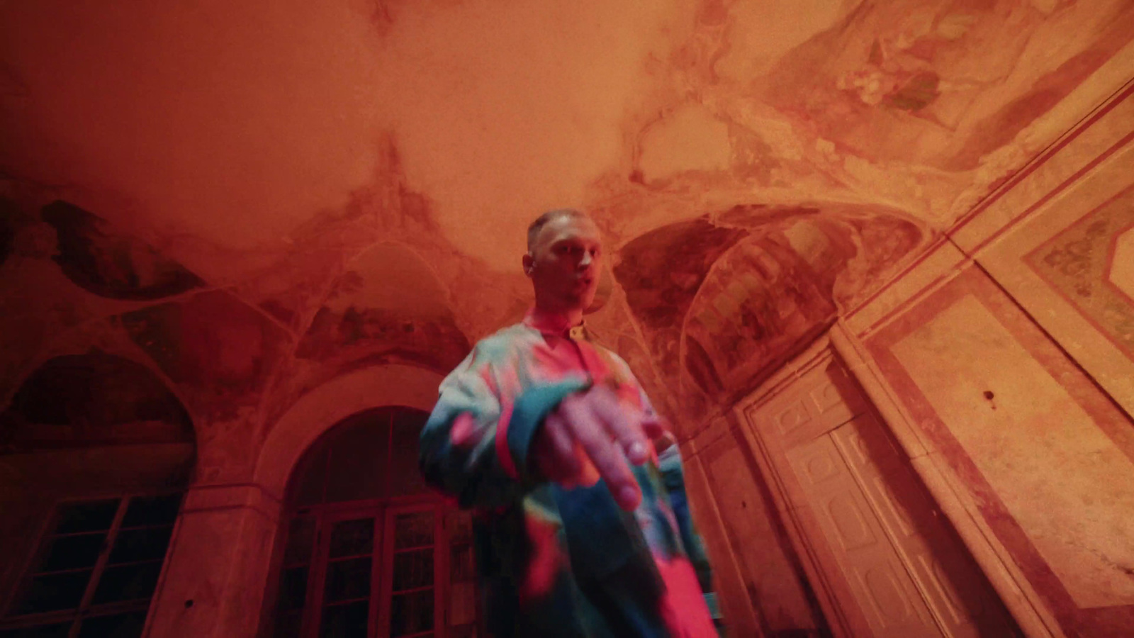 a man standing in a room with a painted ceiling