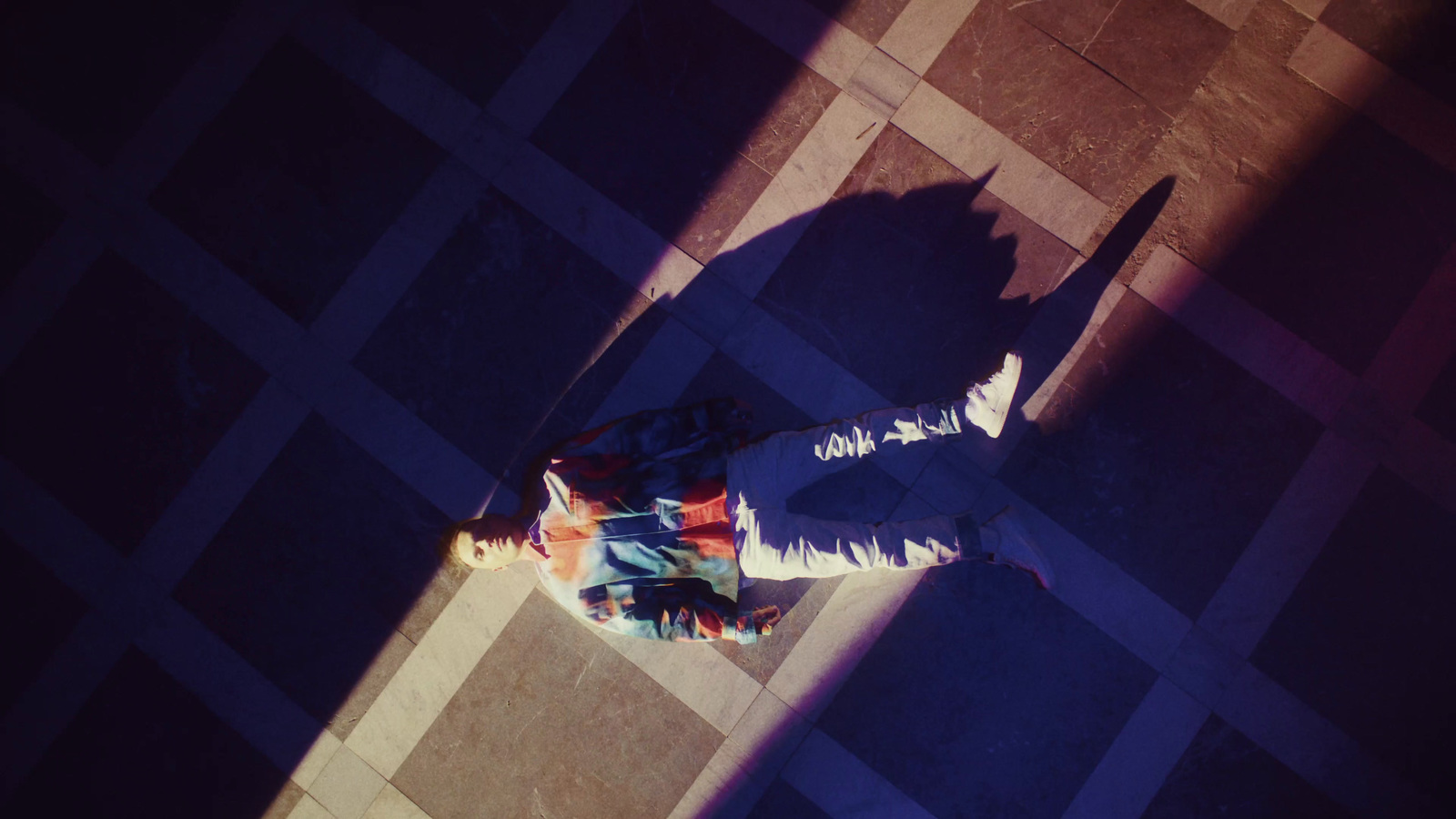 a person standing on a tiled floor next to a skateboard