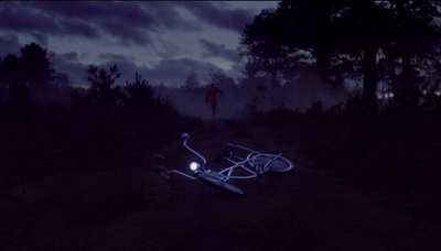 a bike laying on its side in the middle of a forest