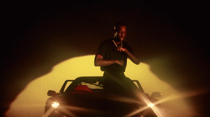 a man standing on top of a car in the dark