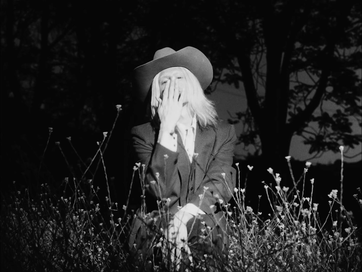 a black and white photo of a woman wearing a cowboy hat