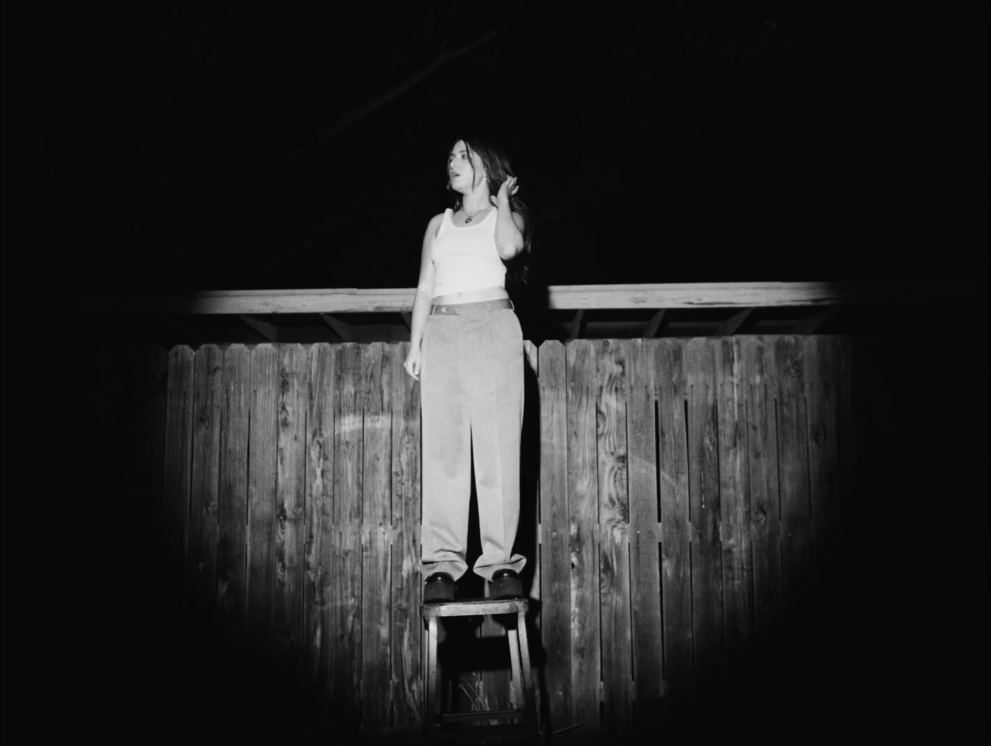 a woman standing on top of a wooden ladder