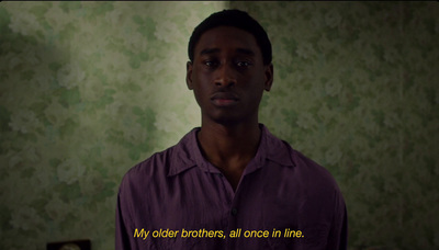 a man standing in front of a wall with a quote on it