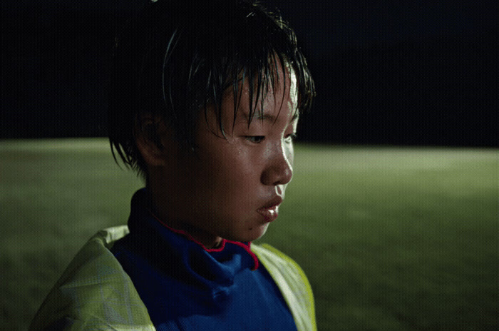 a young boy in a blue and yellow jacket