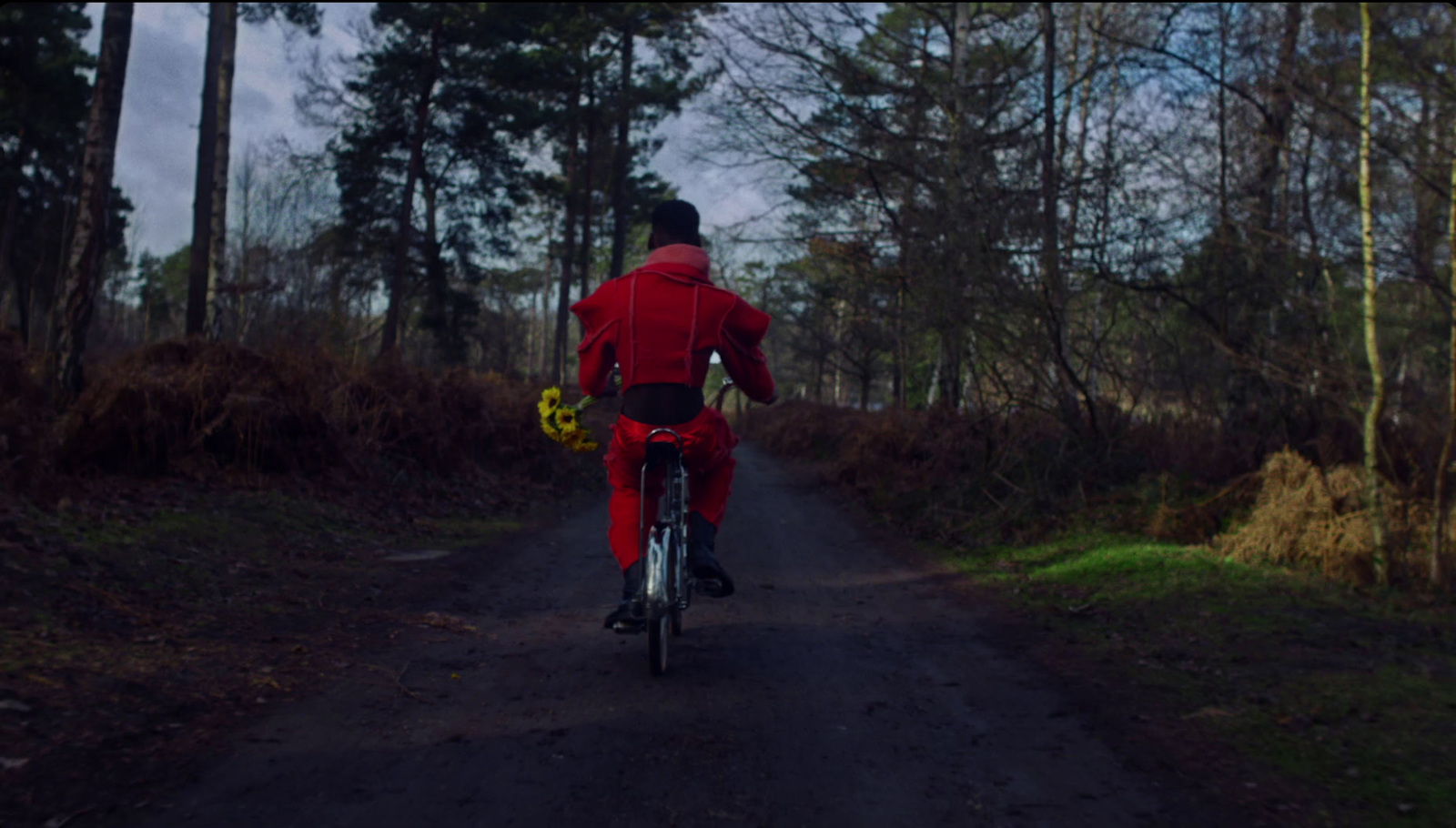 a man riding a bike down a dirt road