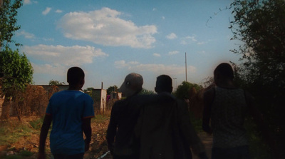 a group of people walking down a dirt road