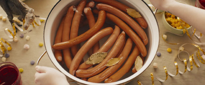 a bowl of hot dogs with mustard and confetti