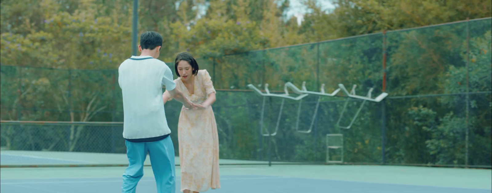 a man and a woman standing on a tennis court