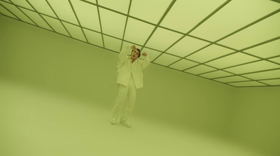 a man in a white suit standing in a room