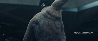 a man with tattoos on his back holding a baseball bat