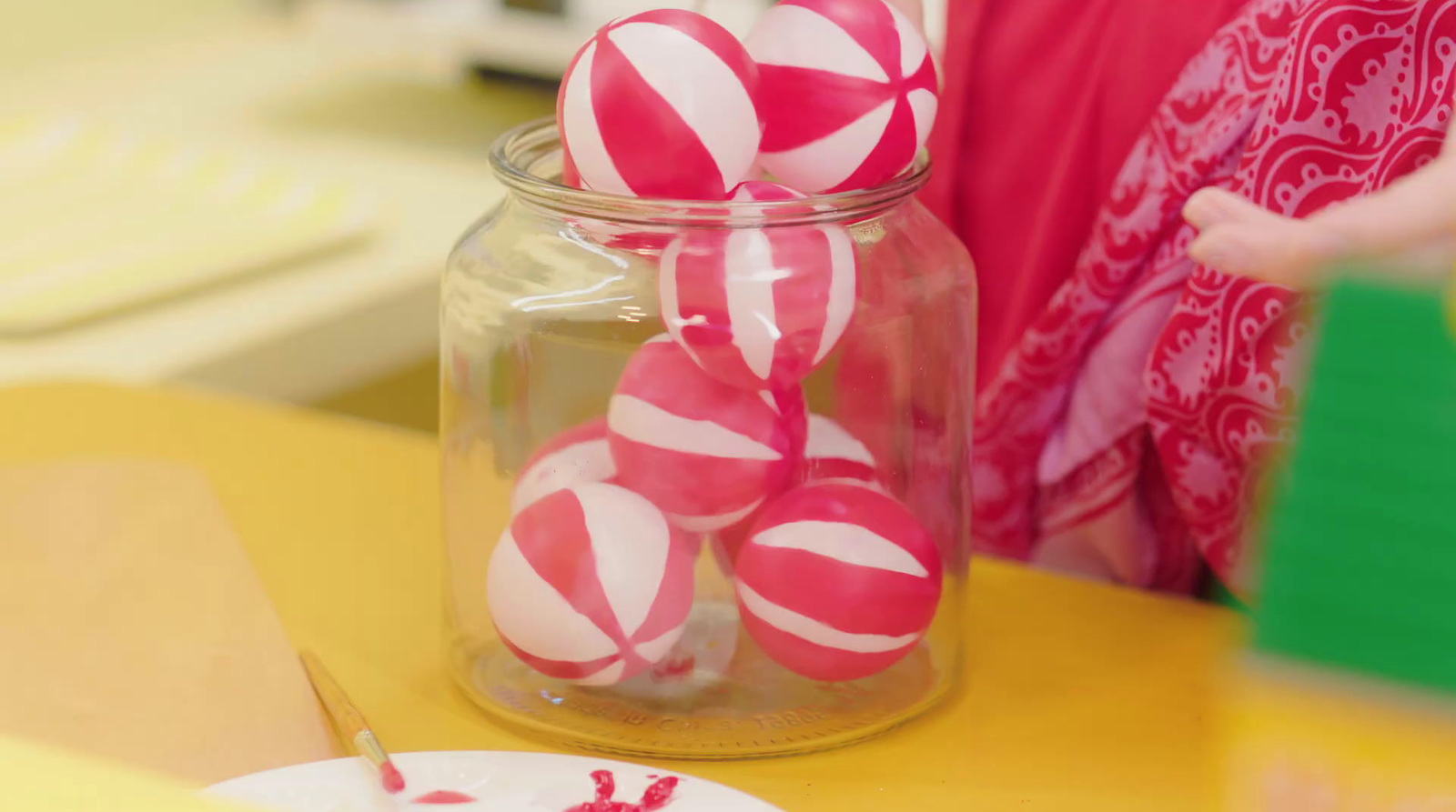 a glass jar filled with candy canes on top of a table